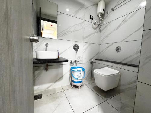 a bathroom with a sink and a toilet and a mirror at Hotel Lee Paramount in Gandhinagar