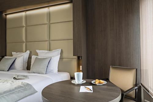 a hotel room with a bed and a table and chair at Residhome Courbevoie La Défense in Courbevoie
