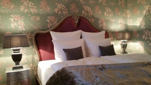 a bedroom with a large white bed with floral wallpaper at Rittergut Rottewitz in Meißen