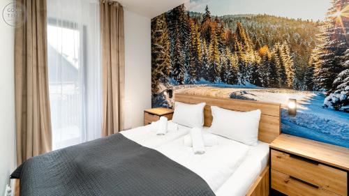 a bedroom with a bed with a painting on the wall at Apartamenty Good Time - Belle View - Centrum in Szklarska Poręba