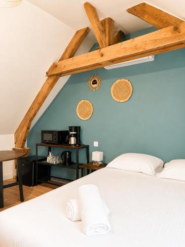 a bedroom with a white bed and a blue wall at Onyx Green in Saint-Aignan