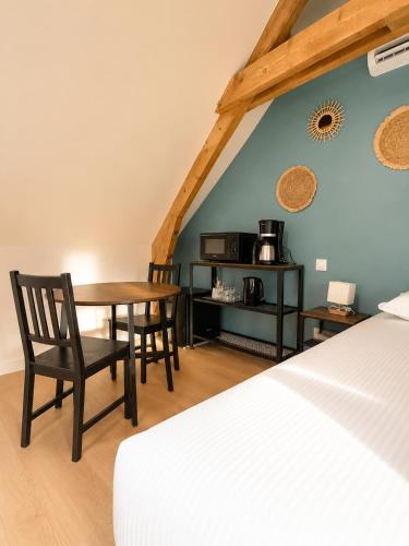a room with a table and chairs and a bed at Onyx Green in Saint-Aignan