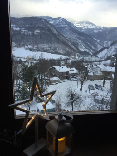a window with a view of a snow covered mountain at R&B Casa Benassi in Riolunato