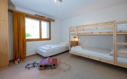 a room with two bunk beds and a table at Garden apartment with mountain views & barbecue in Lenz