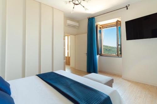 a bedroom with a bed and a large window at casa FraLu in Vico Equense