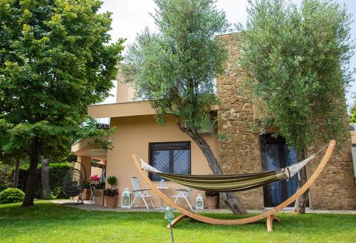 a hammock in front of a house at Anemone Villa, Anthology Villas in Sani with Outdoor Hot Tub, in Sani Beach