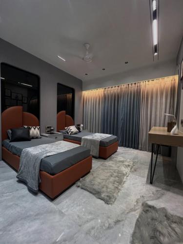 a bedroom with two beds and a desk in it at Hotel The New Pacific Suites Near IGI Airport Delhi in New Delhi