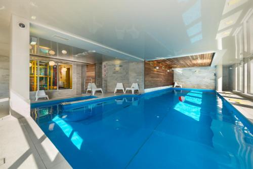 a large pool with blue water in a house at Apartament Marina in Jastarnia