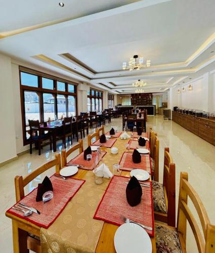 a large dining room with long tables and chairs at Dema Rresort in Paro