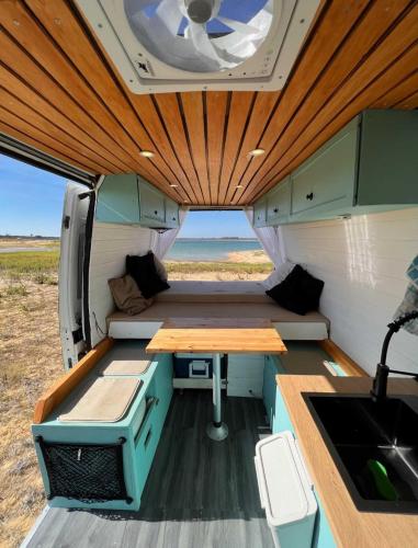an inside view of an rv with a table and a sink at Campervan's Algarve in Albufeira