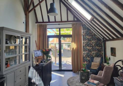 a living room with a large glass door to a patio at Noardlik B&B in Birdaard