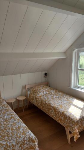 a bedroom with two beds and a window at Ruime Vakantiewoning - Hoeve Niets meer - met eigen privé terras en tuin in Balkbrug
