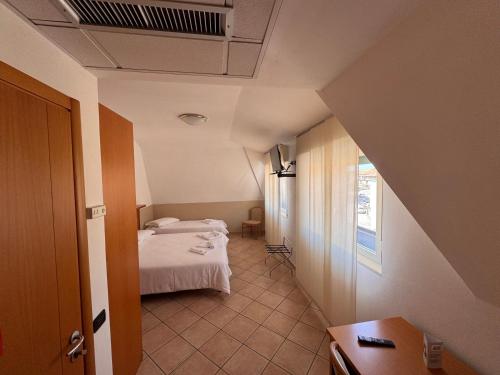 a small room with a bed and a window at Albergo Lario in Gera Lario
