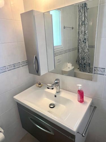 a bathroom with a sink and a mirror at Sea View Pool 2BR Esentepe in Kalogrea