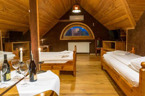 a room with two beds and a table with wine glasses at Krakowiacy i Górale in Krzyszkowice