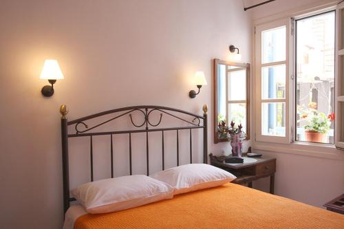 Schlafzimmer mit einem Bett, einem Schreibtisch und einem Fenster in der Unterkunft Panorama Hotel in Naxos Chora
