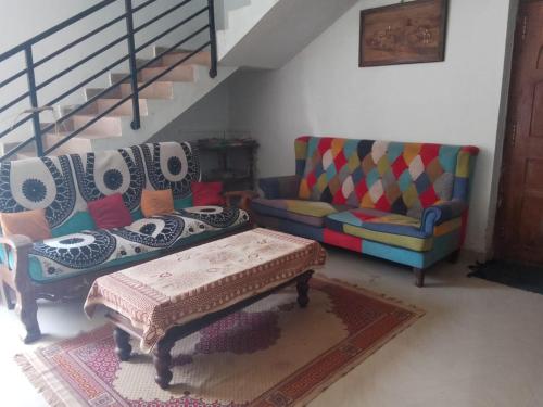 a living room with two chairs and a coffee table at Coorg climate stay in Madikeri