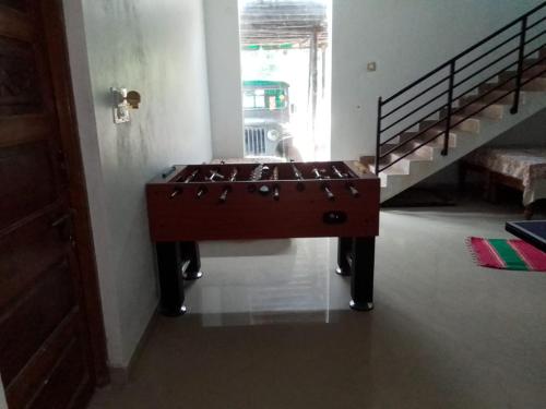 a wooden table in a room with a staircase at Coorg climate stay in Madikeri