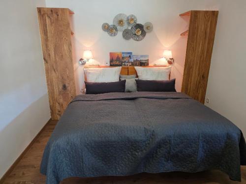 a bedroom with a large bed with a blue blanket at Susann Vendégház in Szigetmonostor