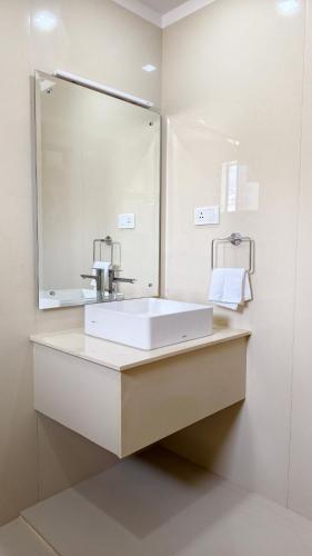 a bathroom with a sink and a large mirror at Estate IV - Saffron Suite - Tea Estate Stay in Vythiri