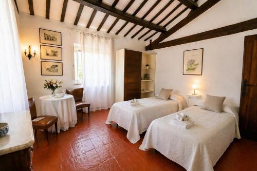 a room with two beds and two tables in it at Casa Adele - 10 min from the sea! in Carignano