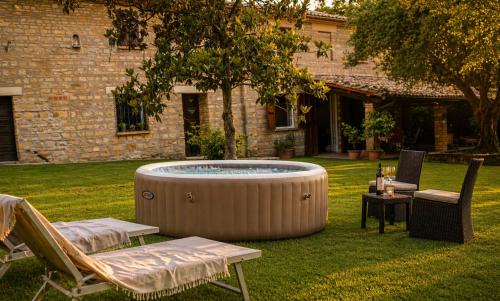 a hot tub in a yard with two chairs and a table at Casa Adele - 10 min from the sea! in Carignano