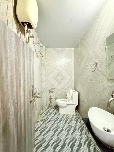 a bathroom with a toilet and a sink at Amba palace in Prayagraj