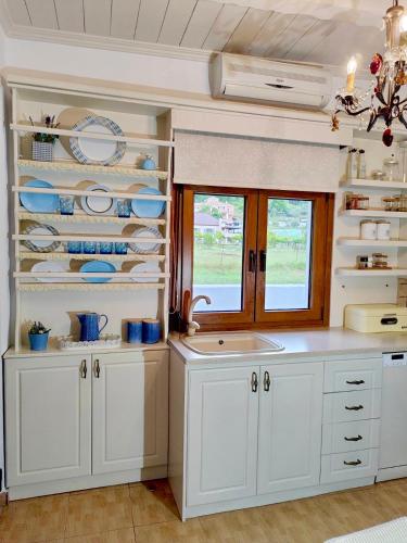 a kitchen with white cabinets and a window at Forest view evia in Prokópion