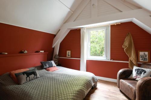 a bedroom with red walls and a bed and a window at Cottages Croix L'abbé, les Mouettes in Saint-Valéry-sur-Somme