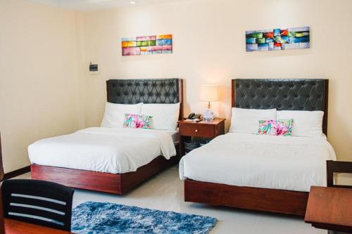 a bedroom with two beds and a table with a lamp at Sabine's Place in Cangbaliguia