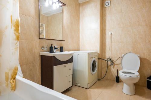 a bathroom with a sink and a washing machine at Summerland Lake View Apartament in Mamaia