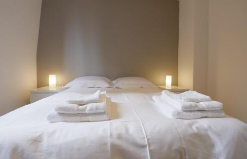 a bedroom with a white bed with towels on it at Appartement Plaisance in Lille
