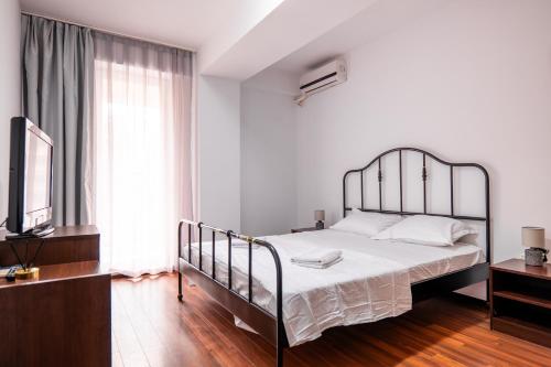 a bedroom with a large bed and a television at Summerland Lake View Apartament in Mamaia
