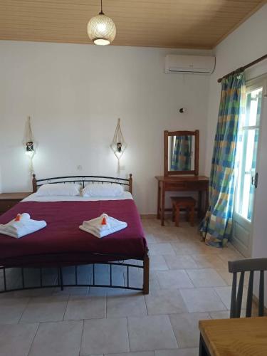 a bedroom with a bed with two towels on it at Dimosthenis Apartments in Agios Georgios