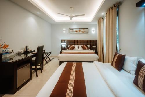 a hotel room with two beds and a desk at Viveka Hotel Colombo in Colombo