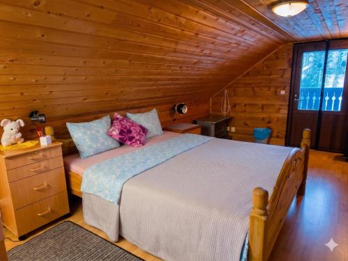 a bedroom with a bed in a wooden cabin at Countryside riverside cabin for both winter and summer in Janakkala