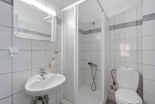 a bathroom with a toilet and a sink and a shower at Sivotahomes - Noah in Syvota