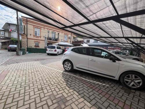 a white car parked under a covered parking lot at Rooms Filip in Bitola