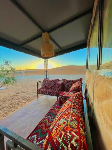 a bed in a room with a view of the desert at Camp Luxury in Merzouga in Merzouga