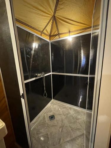 a shower with a glass door in a bathroom at Camp Luxury in Merzouga in Merzouga