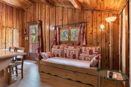 a bedroom with a bed in a log cabin at Camping L'imprévu in Vaulnaveys-le-Bas