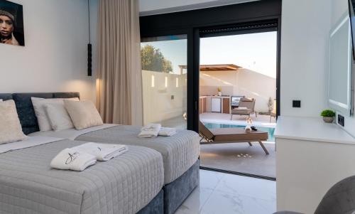 two beds in a bedroom with a view of a pool at Amfi Luxury Villa 4BR with Private Pool by Villa Mana Gers in Sarakinádhon