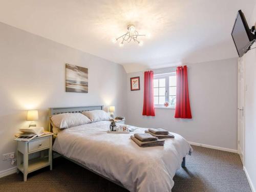 a bedroom with a bed and a window with red curtains at 1 Bed in Cinderford oc-88271 in Cinderford