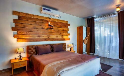 a bedroom with a large bed with a wooden wall at WayFare Stud Farm & Resort in Nashik