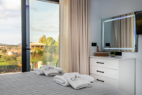 a bedroom with a white bed with a large window at Amfi Luxury Villa 4BR with Private Pool by Villa Mana Gers in Sarakinádhon