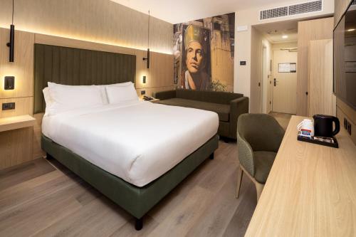 a hotel room with a large bed and a couch at Holiday Inn Naples by IHG in Naples