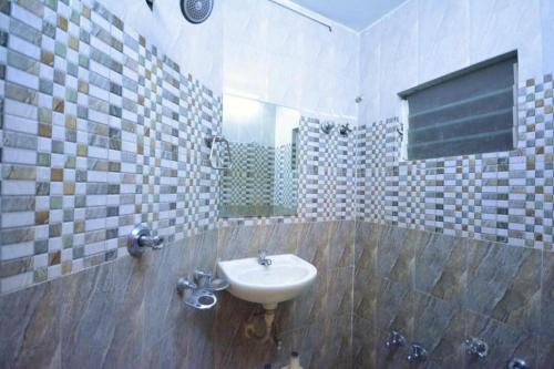 a bathroom with a sink and a mirror at Hotel Jasmine in Ahmedabad