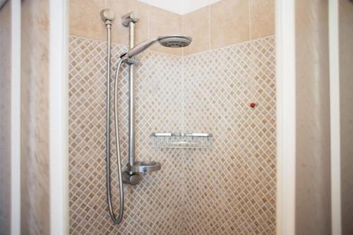 a shower with a shower head in a bathroom at A'Luara in San Roberto