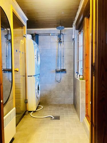 a bathroom with a washing machine and a shower at Countryside riverside cabin for both winter and summer in Janakkala