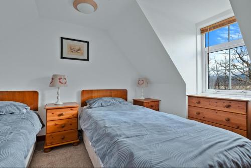 a bedroom with two twin beds and a window at Lochead Cottage Ellary in Lochgilphead